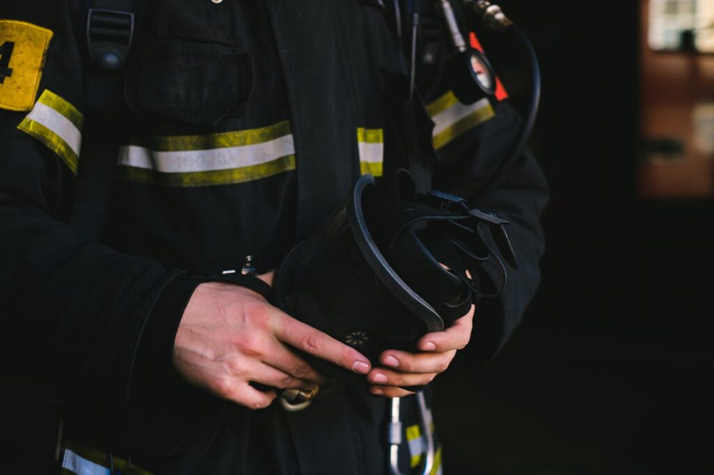 Detailed view of a firefighter's hands holding essential safety equipment, showcasing uniform and gear.